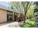 Brick home exterior with wooden deck, spacious yard and mature trees at 24 Spyglass Dr, Littleton, CO 80123