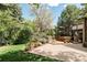 Backyard features a landscaped yard, mature trees, spacious patio, and hot tub at 24 Spyglass Dr, Littleton, CO 80123