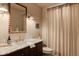 Bright bathroom features a marble vanity, wood-trimmed mirror, and shower with neutral curtains at 24 Spyglass Dr, Littleton, CO 80123