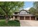 Charming home with meticulous lawn, mature trees, four car garage, and Tudor style architecture at 24 Spyglass Dr, Littleton, CO 80123