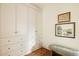 Hallway features extensive white storage cabinetry and light herringbone wood flooring at 24 Spyglass Dr, Littleton, CO 80123