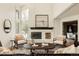 Bright living room features fireplace, large windows, hardwood floors and open floor plan at 24 Spyglass Dr, Littleton, CO 80123