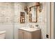 Stylish powder room featuring floral wallpaper, a marble countertop, and elegant lighting at 24 Spyglass Dr, Littleton, CO 80123