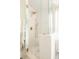 Modern walk-in shower with glass enclosure, white tile, and stylish gold fixtures at 24 Spyglass Dr, Littleton, CO 80123
