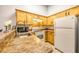 Updated kitchen with wood cabinetry, modern appliances, and breakfast bar at 919 S Dawson Way # 17, Aurora, CO 80012
