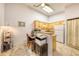 Functional kitchen area with wood cabinets, countertops, and an adjacent workspace at 919 S Dawson Way # 17, Aurora, CO 80012