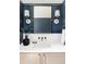 Stylish bathroom vanity with blue walls, brass fixtures, and a custom mirror at 1968 S Washington St, Denver, CO 80210