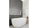 Modern bathroom featuring a soaking tub and sleek fixtures with a textured black accent wall at 1968 S Washington St, Denver, CO 80210