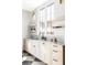 Bright laundry room boasts a farmhouse sink, marble counters, and open shelves underneath a big window at 1968 S Washington St, Denver, CO 80210