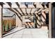 Covered outdoor patio with timber pergola, brick wall and a view to the interior through folding doors at 1968 S Washington St, Denver, CO 80210