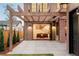 Outdoor patio featuring timber pergola, brick wall, a seating area, and folding doors to the home's interior at 1968 S Washington St, Denver, CO 80210