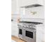 Stainless steel double oven with gas range, complemented by white cabinetry and a pot filler at 1968 S Washington St, Denver, CO 80210