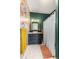 Bright bathroom features colorful floral wallpaper, dark green paint, and black vanity at 2465 W Caithness Pl, Denver, CO 80211