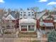 Two-story home with a covered porch nestled between other well-maintained homes at 2465 W Caithness Pl, Denver, CO 80211