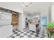 Updated kitchen with black and white floors, ample storage, island, and stainless steel appliances at 2465 W Caithness Pl, Denver, CO 80211