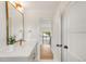 Bright bathroom vanity area features gold fixtures, white walls, and a decorative plant at 4452 Xavier St, Denver, CO 80212