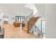 Bright and spacious foyer with hardwood floors, an open staircase, and a view into the living area at 4452 Xavier St, Denver, CO 80212