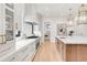 Bright kitchen featuring white cabinets, marble countertops, a gas range, and pendant lighting at 4452 Xavier St, Denver, CO 80212