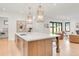 Bright kitchen featuring a large island with seating, wood cabinetry, and views into the living area at 4452 Xavier St, Denver, CO 80212