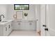 Bright laundry room with white cabinets, light countertops, and black hardware at 4452 Xavier St, Denver, CO 80212