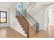 Wooden staircase with black railings leads to the upper level, flooded with natural light from nearby windows at 4452 Xavier St, Denver, CO 80212
