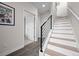 Entryway with staircase featuring sleek black railings and light wood treads and gray tile floor at 3480 E 31St Ave, Denver, CO 80205