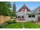 Well-manicured backyard with green lawn, patio with dining set, raised garden beds, and perimeter fencing at 3424 W 31St Ave, Denver, CO 80211