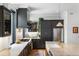 Modern kitchen with dark cabinetry, stainless steel appliances, and marble countertops at 3424 W 31St Ave, Denver, CO 80211