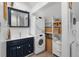 Functional laundry room with stacked washer/dryer, storage shelves, and a stylish sink at 3424 W 31St Ave, Denver, CO 80211