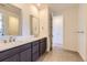 Bathroom featuring double sinks, wooden cabinets, large mirrors, and stylish tile flooring at 3979 Descent St, Castle Rock, CO 80108