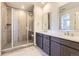 Bright bathroom featuring double sinks, large shower, and a vanity with modern fixtures at 3979 Descent St, Castle Rock, CO 80108