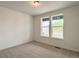 A carpeted bedroom showcases two windows providing exterior views and natural light at 3979 Descent St, Castle Rock, CO 80108