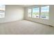 A sunlit bedroom features plush carpeting and large windows showcasing scenic views at 3979 Descent St, Castle Rock, CO 80108