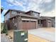 Side view of a home with stone and brown siding, three-car garage, and landscaping at 3979 Descent St, Castle Rock, CO 80108
