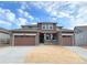 Beautiful two-story home with brown siding, stone accents, and a three-car garage at 3979 Descent St, Castle Rock, CO 80108