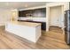 Modern kitchen boasts an island, stainless appliances, dark cabinets and hardwood flooring at 3979 Descent St, Castle Rock, CO 80108