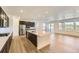 Open-concept kitchen with stainless steel appliances, quartz island, dark cabinetry and hardwood flooring at 3979 Descent St, Castle Rock, CO 80108