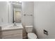 Clean half bathroom with white fixtures including sink, vanity, toilet, and mirror at 5441 Lynx St, Frederick, CO 80504