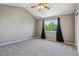 Vaulted ceiling in bedroom with gray walls, neutral carpet, a ceiling fan, and a view of the lush outdoors at 5441 Lynx St, Frederick, CO 80504