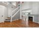 Spacious living room featuring vaulted ceiling, fireplace, gleaming hardwood floors, and a staircase to the upper level at 5441 Lynx St, Frederick, CO 80504