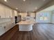 Bright kitchen features a large island, modern appliances, white cabinets, and wood-look flooring at 283 Wooten Ave, Brighton, CO 80601