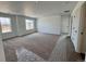 A large living room with carpet flooring and many windows providing plenty of natural light at 283 Wooten Ave, Brighton, CO 80601