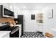Cozy kitchen featuring stainless steel appliances, decorative accents, and black and white tiled floor for a modern touch at 2313 S Race St # A, Denver, CO 80210