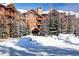 Exterior showcasing rustic architecture with a porte cochere and snow covered grounds at 50 Mountain Thunder Dr # 1212, Breckenridge, CO 80424