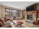 Cozy living room featuring a stone fireplace, large window with wooded views, and comfortable seating at 50 Mountain Thunder Dr # 1212, Breckenridge, CO 80424