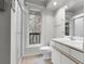 Bright bathroom with a shower, a toilet, vanity and a window looking out to a tree and balcony at 150 Soda Creek Rd, Evergreen, CO 80439