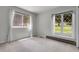 Bedroom with two large windows and natural light, offering a serene view and cozy carpet flooring at 150 Soda Creek Rd, Evergreen, CO 80439
