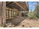 Covered ground floor exterior featuring multiple large windows and mature landscaping at 150 Soda Creek Rd, Evergreen, CO 80439