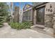 Close-up of home's entry, highlighting the stone facade, Tudor detailing, and the front door with glass window at 150 Soda Creek Rd, Evergreen, CO 80439