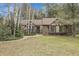 Charming home featuring stone accents, Tudor-style detailing, and a well-maintained lawn, nestled amongst mature trees at 150 Soda Creek Rd, Evergreen, CO 80439